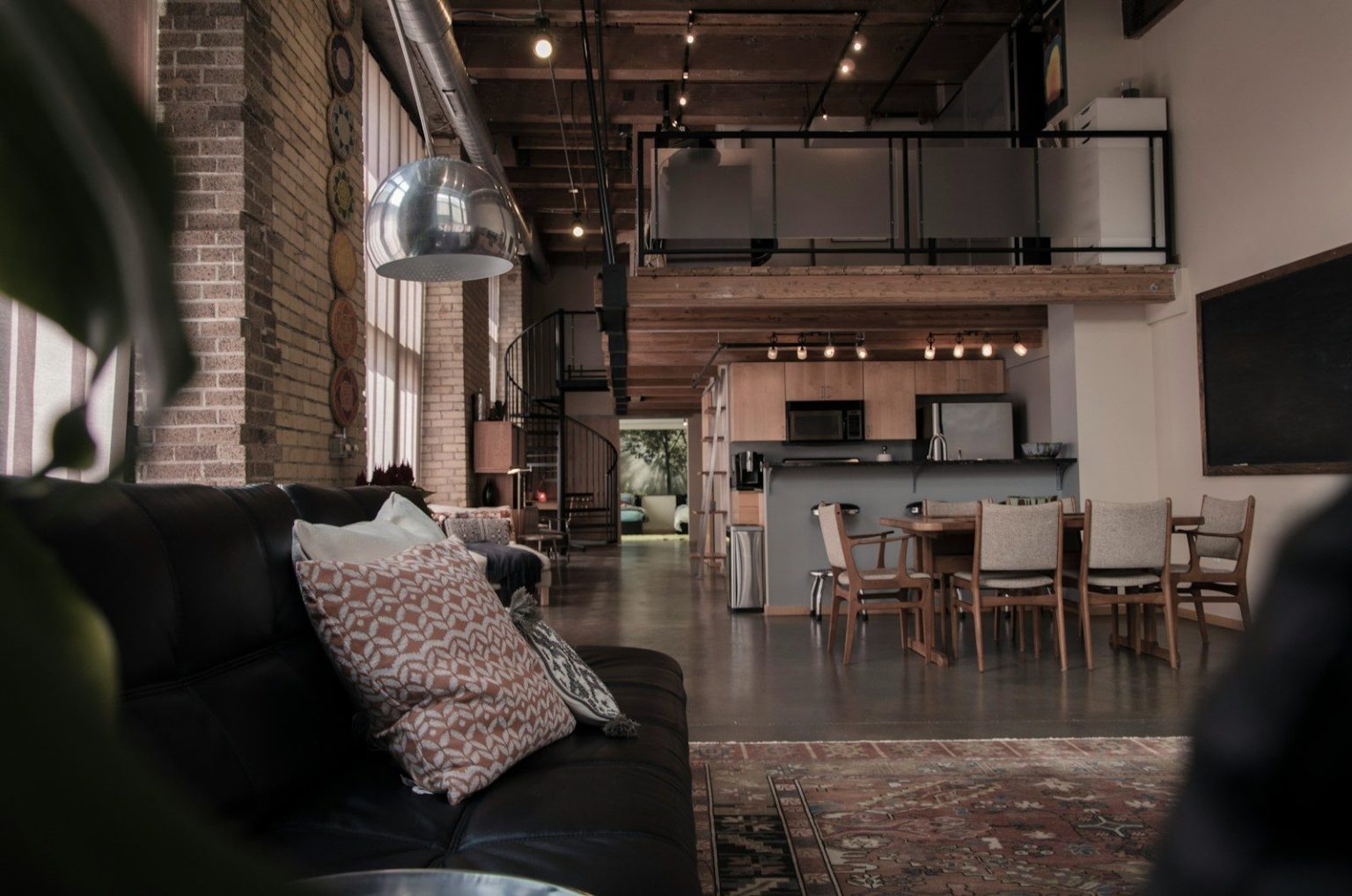Photo by Aaron Huber black leather couch with gray throw pillwo